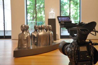 A camera captures Brian Doan's artworks. 