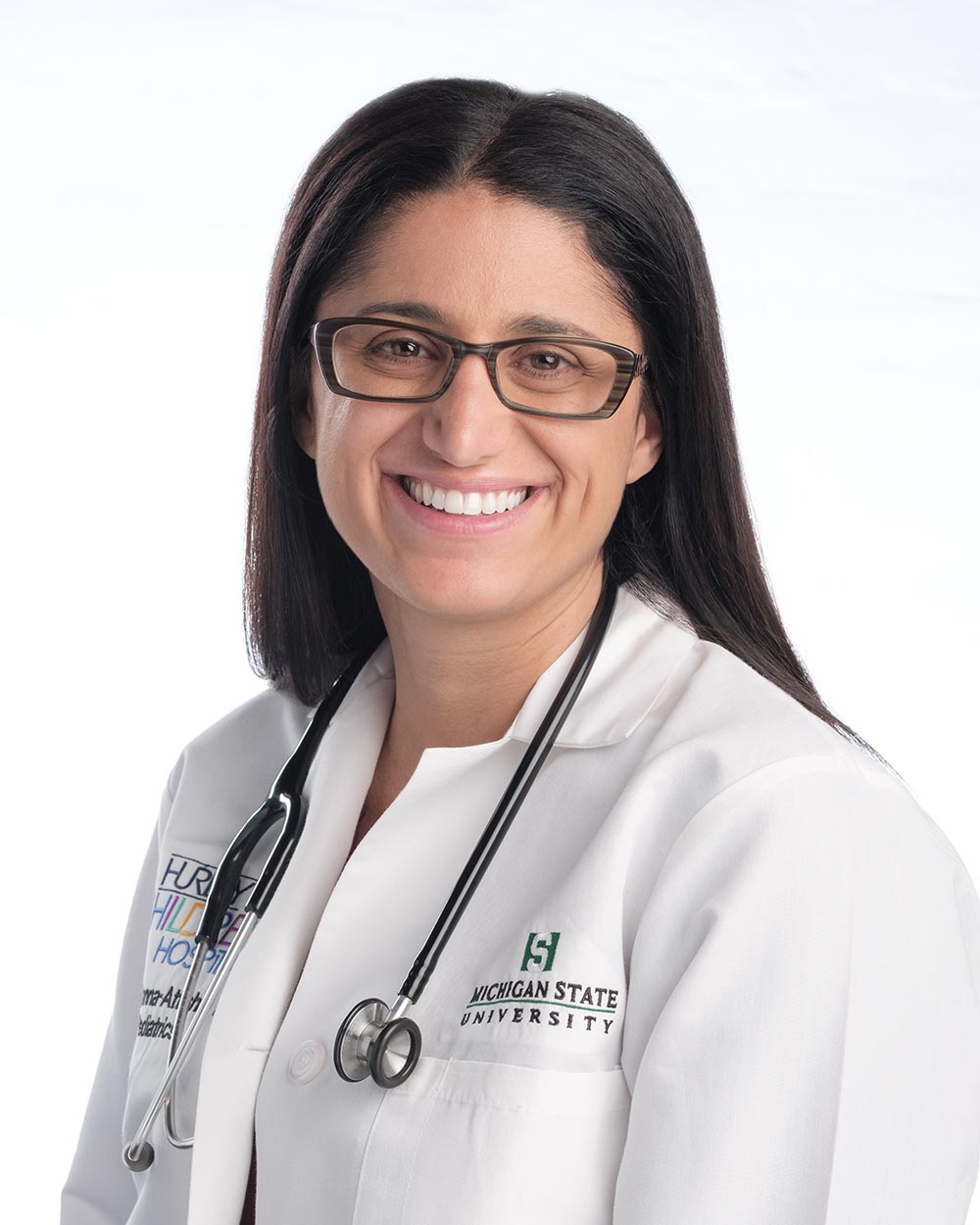 A portrait of Dr. Mona Hanna-Attisha in a lab coat.