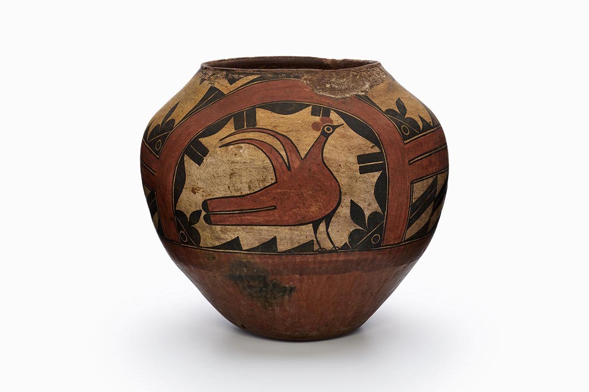 A Zia pot with a large bird in the center surrounded by black and brown patterns.