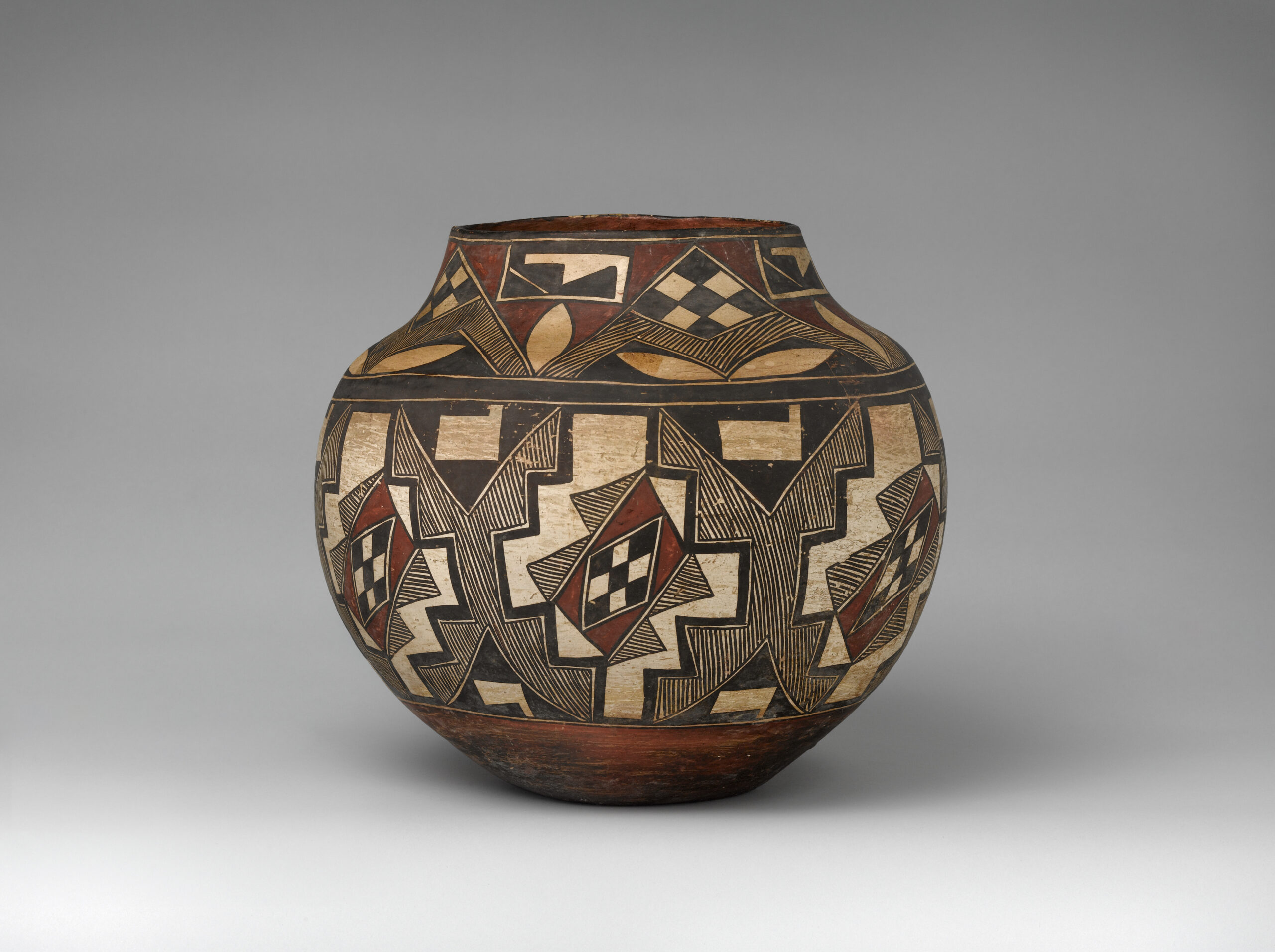 An Acoma jar with two bands of checkered, linear, and geometric patterns in black, beige, and rust-brown pigments.