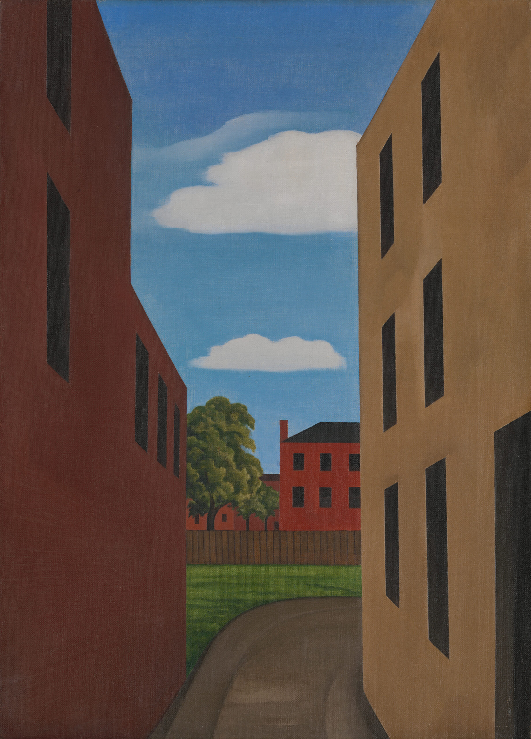 A narrow dirt driveway between two tall buildings curves to reveal another building, a tree, and sky.