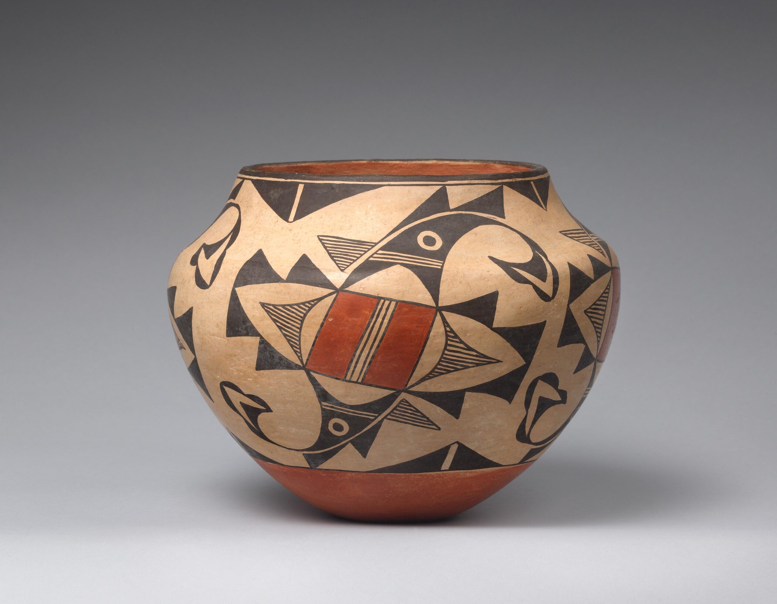 Acoma jar painted beige, rust orange, and black, with an abstract bird design.