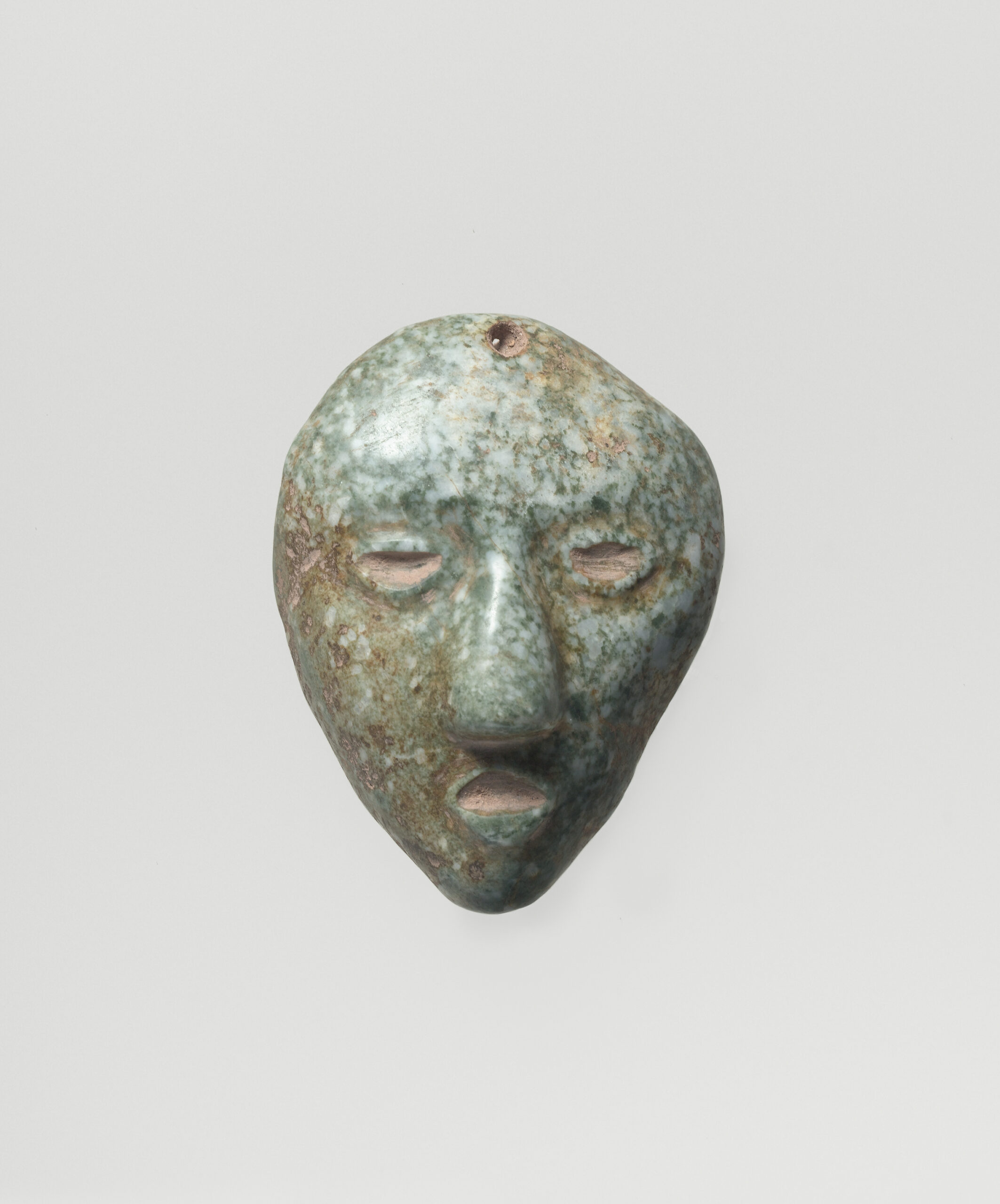 Small stone pendant of a head with an open mouth and large nose.