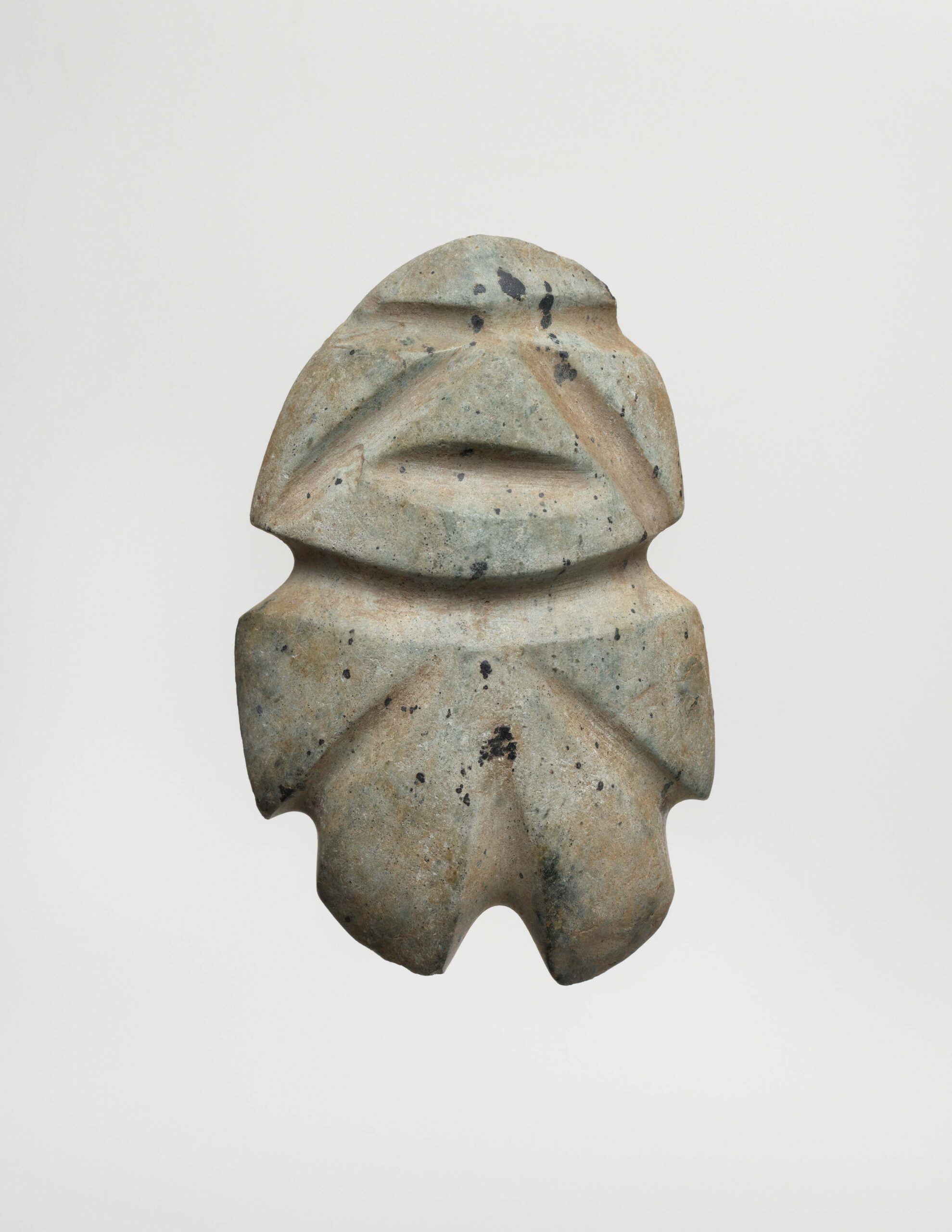 Small abstract standing figure with indented features.