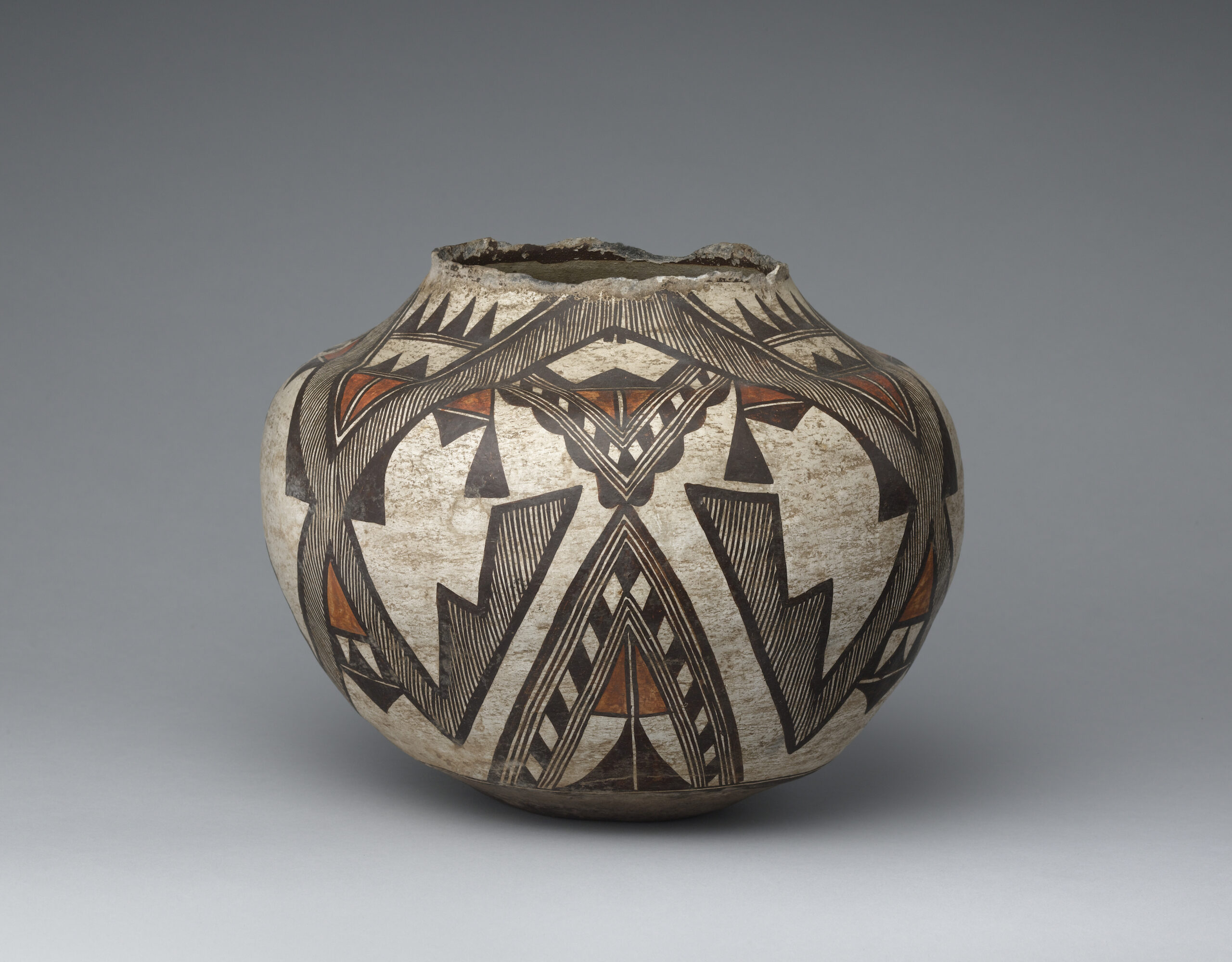 A Zuni olla with a stylized wing design primarily composed of lines and triangular shapes.