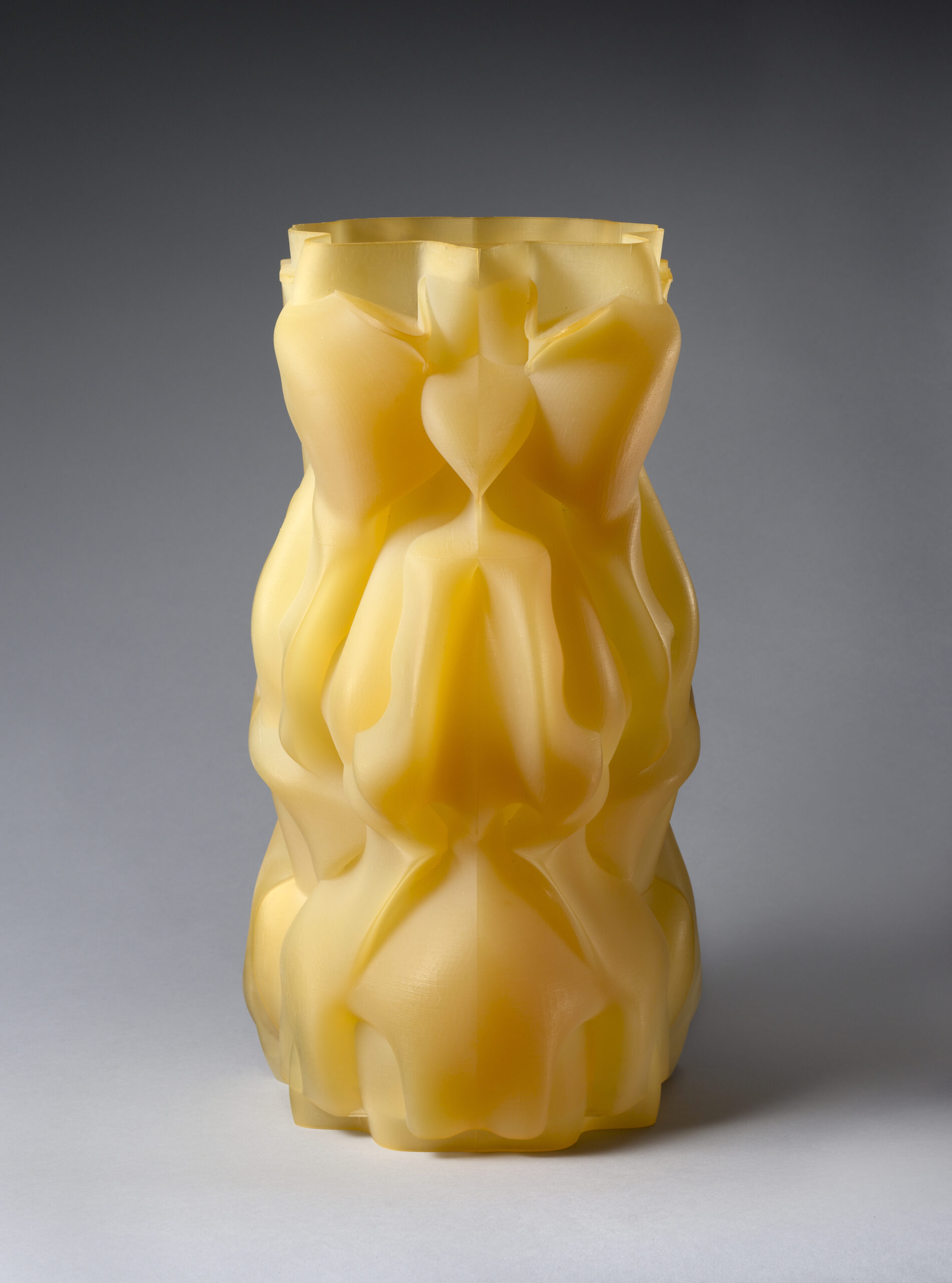 Translucent yellow abstract sculpture with multiple folds.