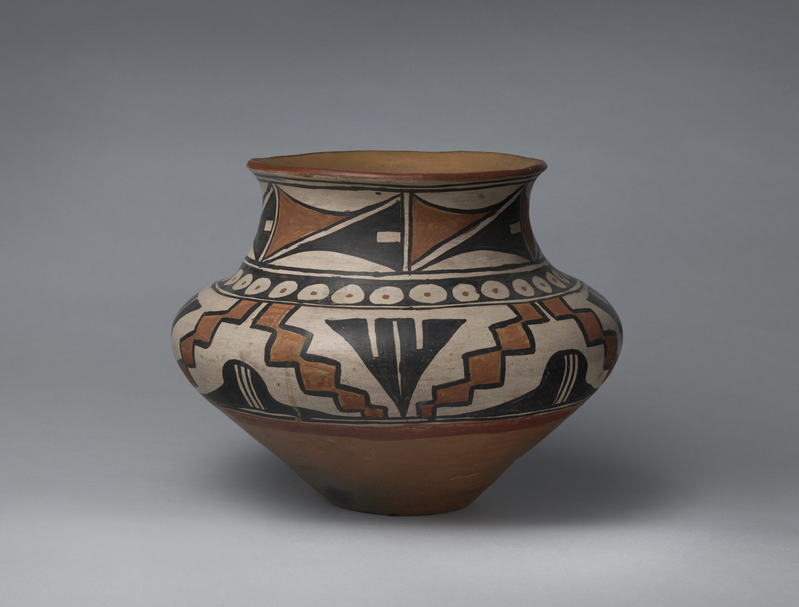 A San Ildefonso jar with three bands of black and brown geometric designs.