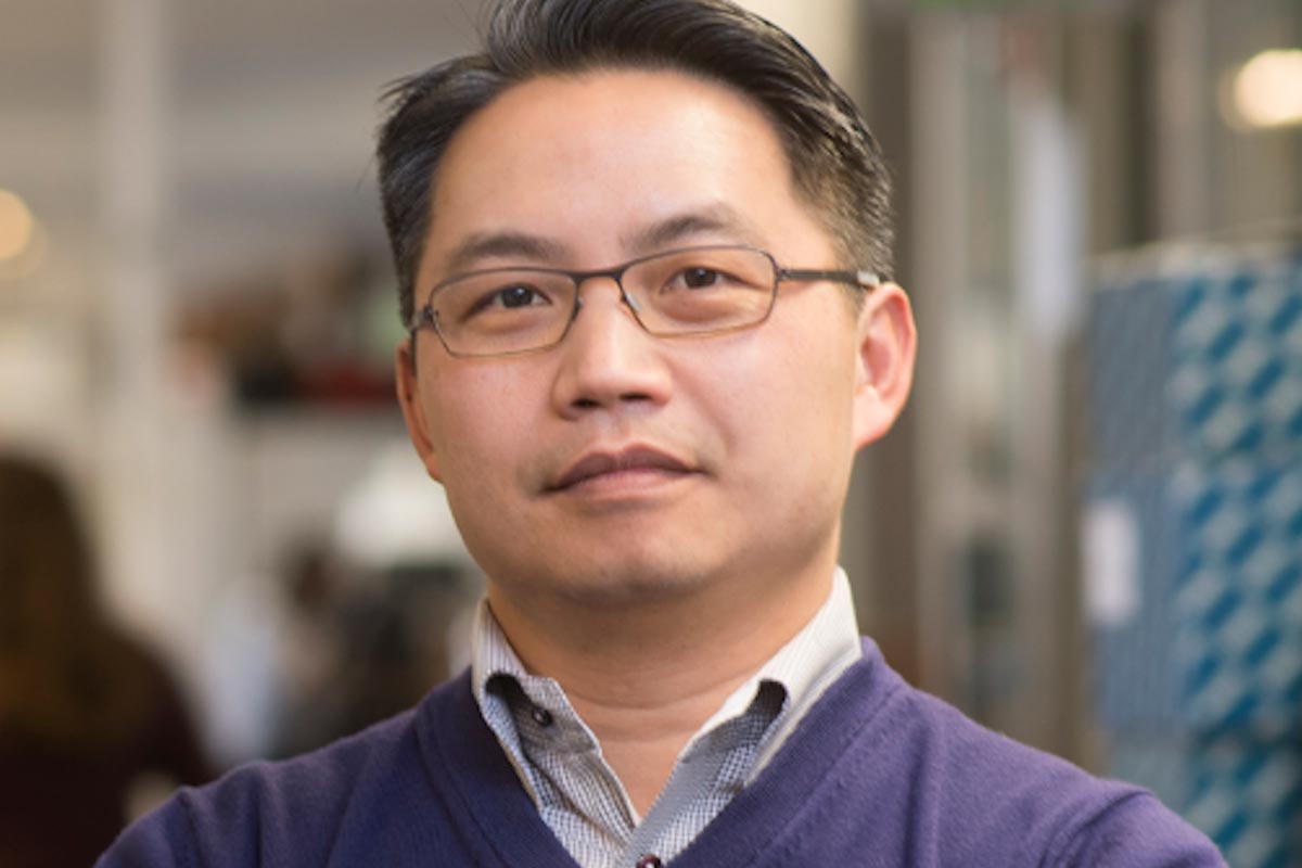 A photo of Howard Chang in a dress shirt and purple sweater.