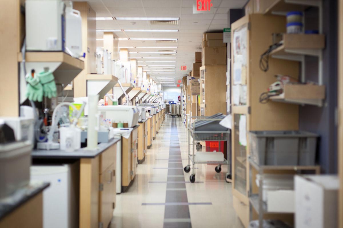 A photograph of a research laboratory showcasing numerous stations with lab equipment extending down the aisle and into the distance.