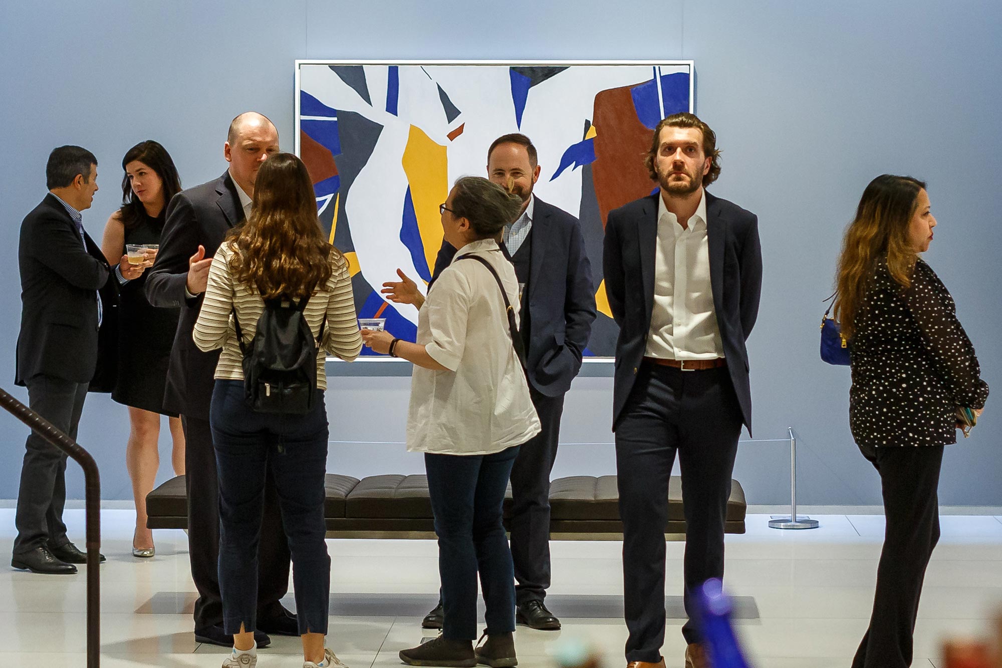 Seamus McKillop stands in a crowd of people at an opening reception of Ralston Crawford's work at the Vilcek Foundation.