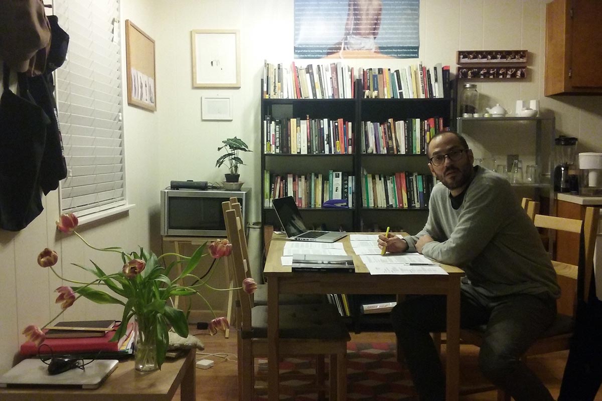 Juan Pablo González sits at a dining room table in his Austin, TX apartment.