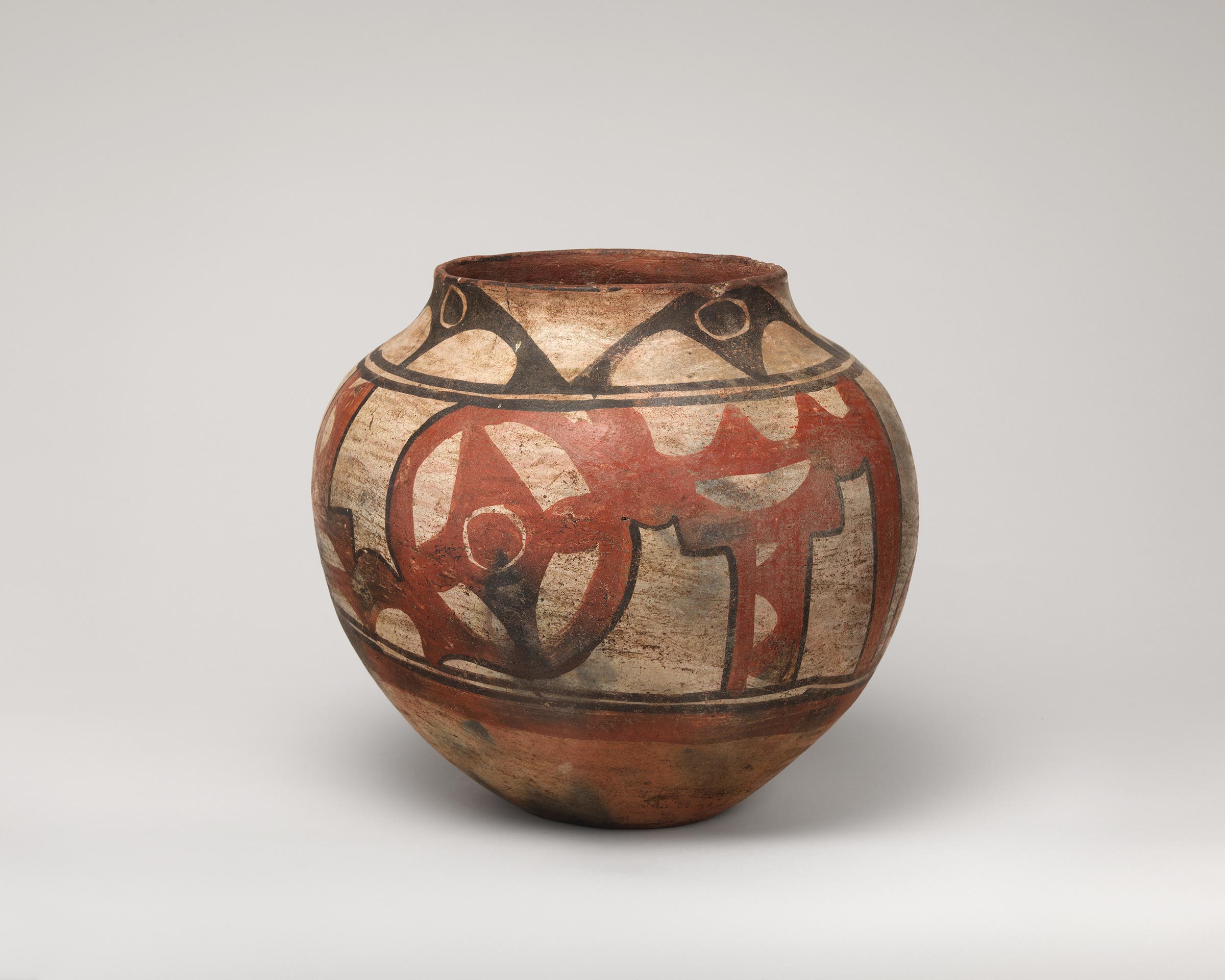 Santa Ana polychrome water jar featuring white slip with black and red painted decoration.