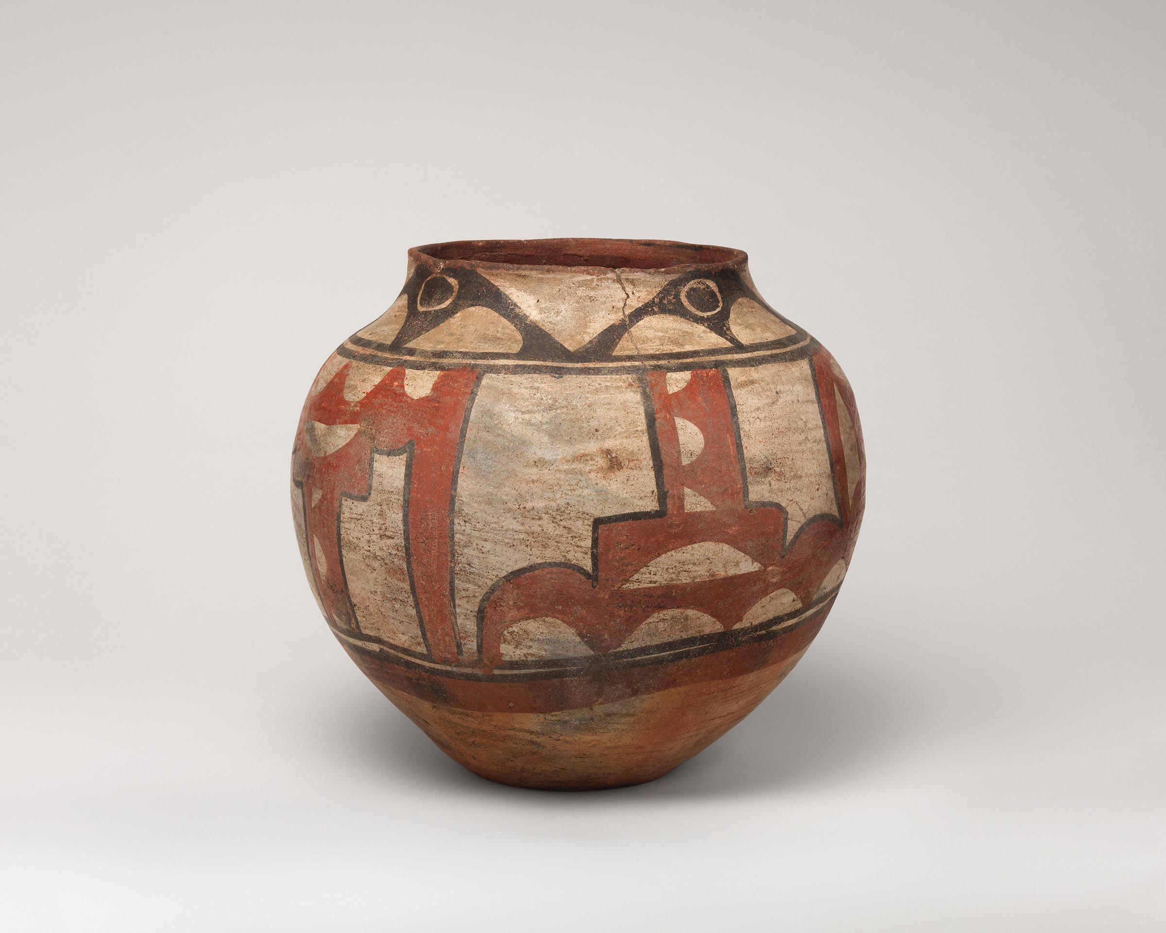 Santa Ana polychrome water jar featuring white slip with black and red painted decoration.