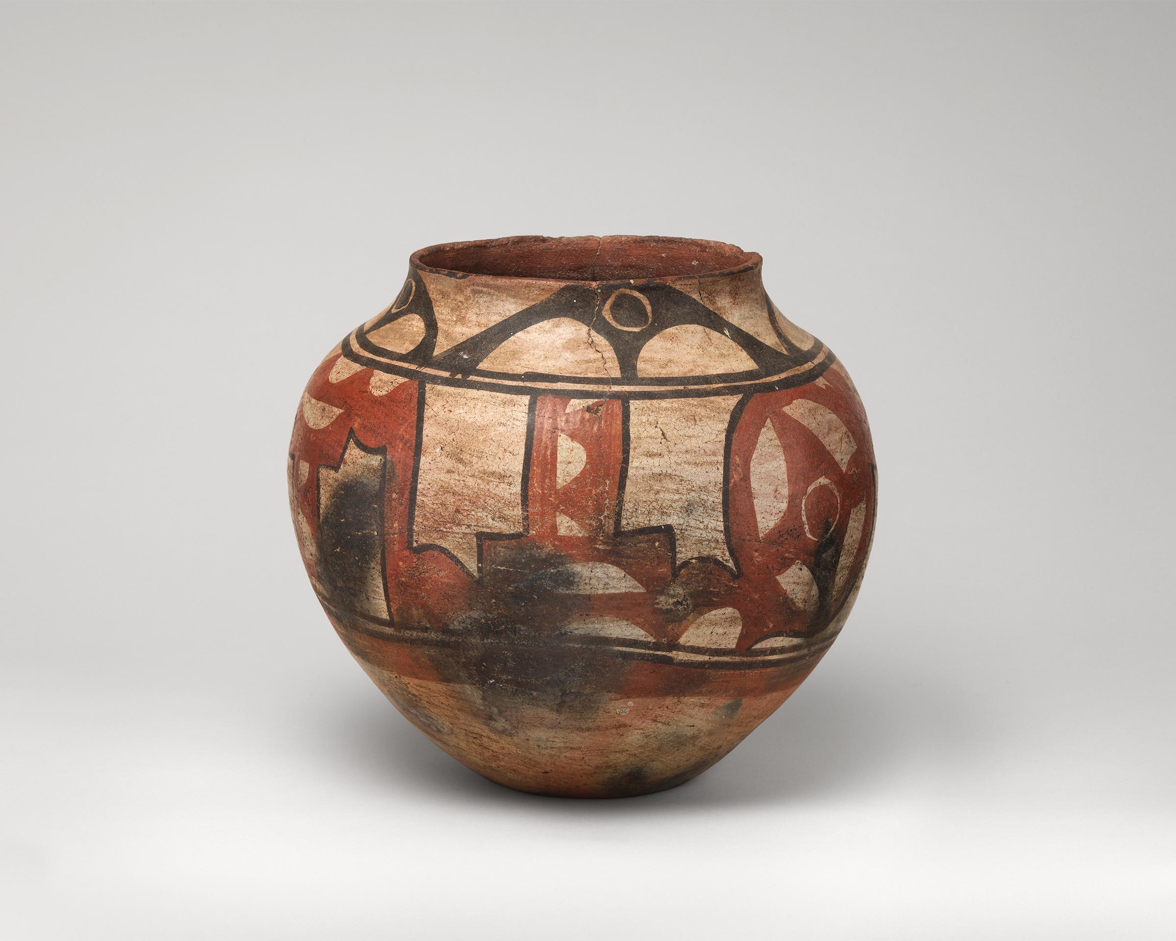 Santa Ana polychrome water jar featuring white slip with black and red painted decoration.