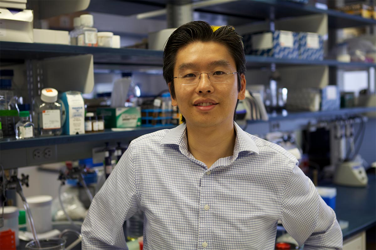 Harris Wang standing in a lab in front of scientific equipment.