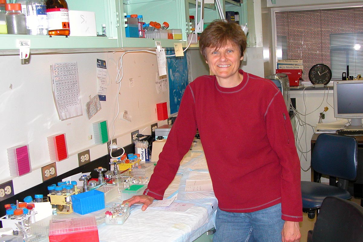 Katalin Karikó, leaning on a lab bench, in her science lab at the University of Pennsylvania in 2005.
