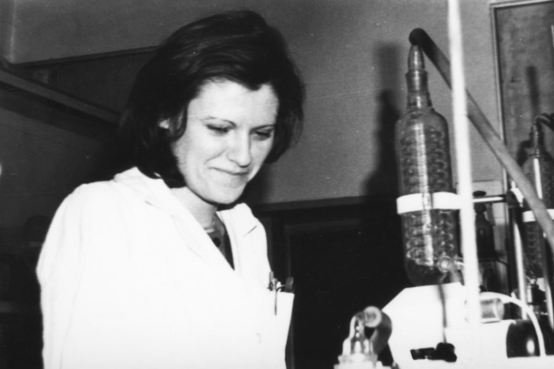 A black and white photo of Katalin Karikó, wearing a lab coat, at the Szeged Biological Research Centre in 1980.