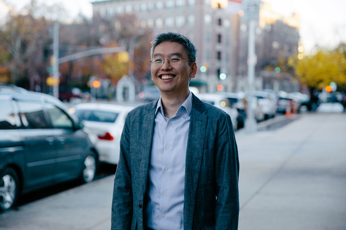 Harris Wang smiling as he walks down a street.