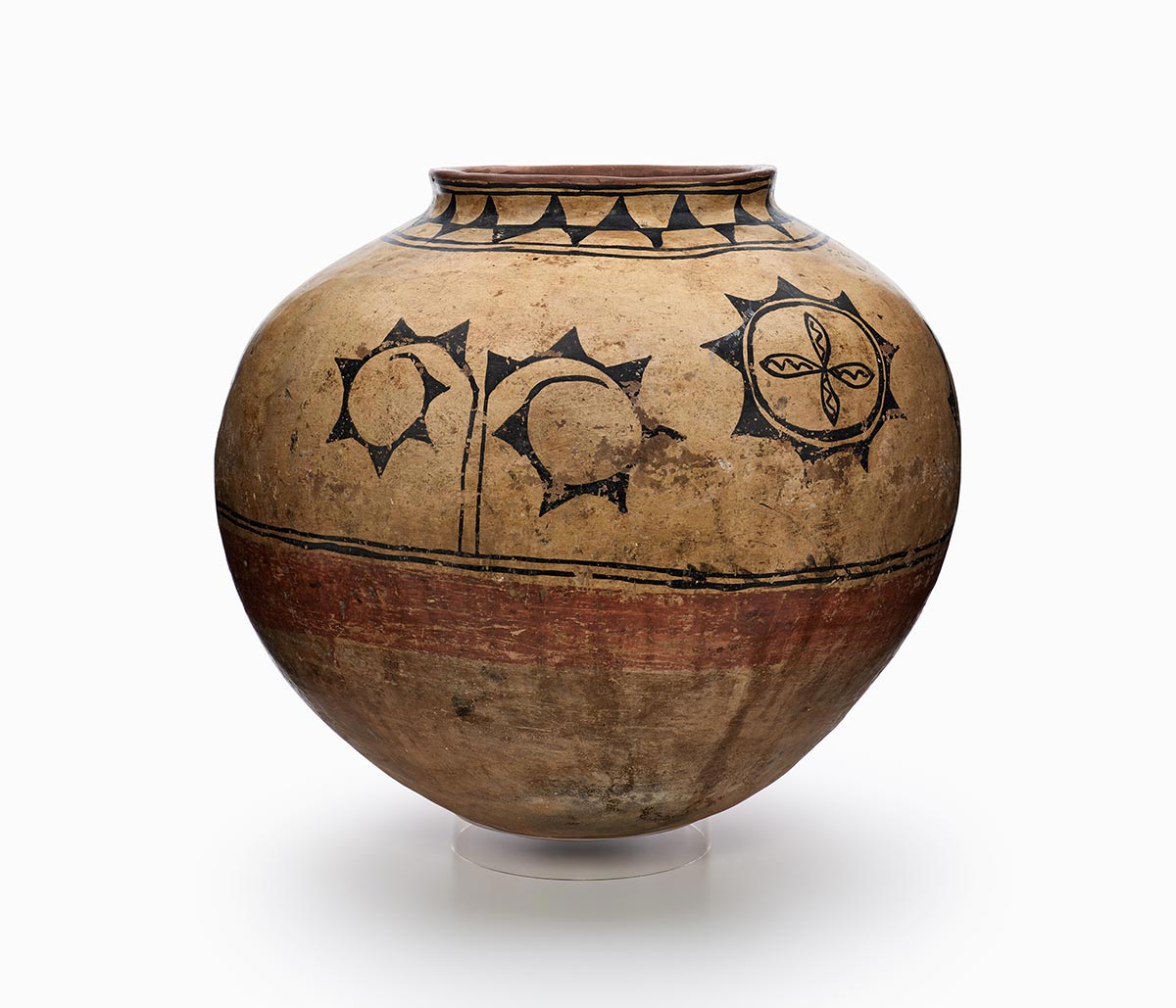 A three-color Cochiti Kiua storage jar features white slip with black and red painted decoration.