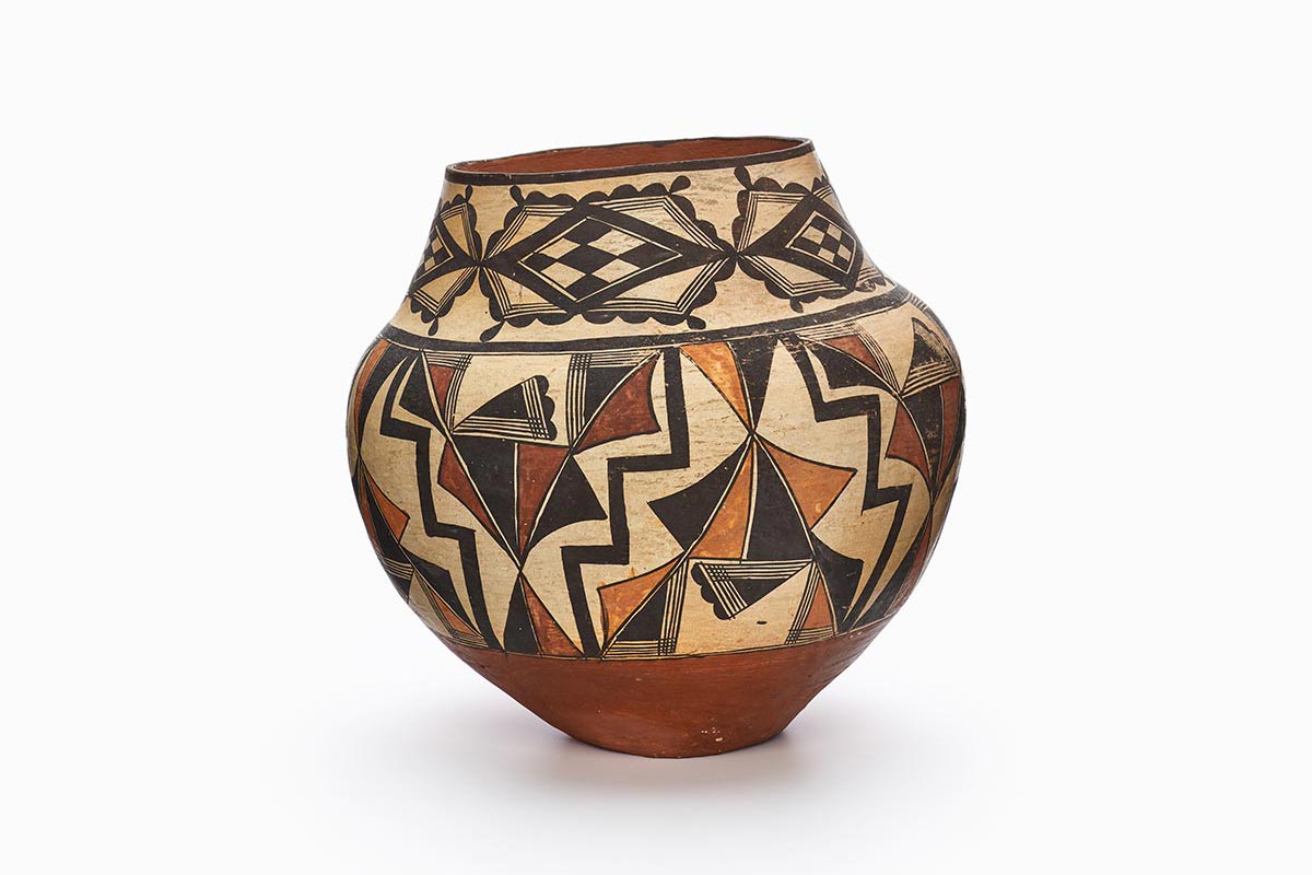 A four-color Acoma polychrome jar featuring white slip with black, red, and orange painted decoration.