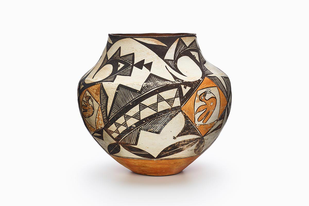 An Acoma jar with black-and-white geometric bands around an orange parrot motif.