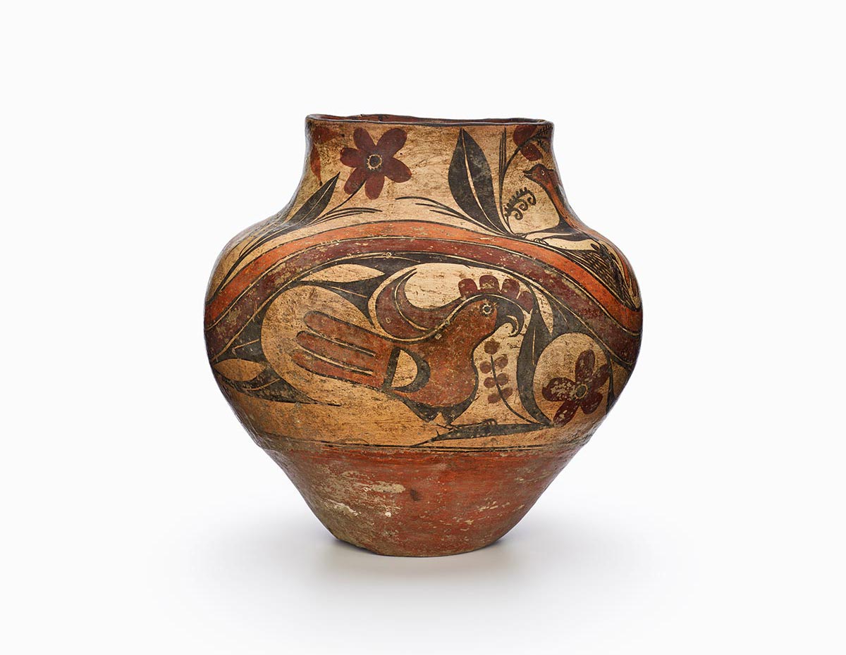An Acoma polychrome olla decorated with birds and flora in black, browns, and rust.