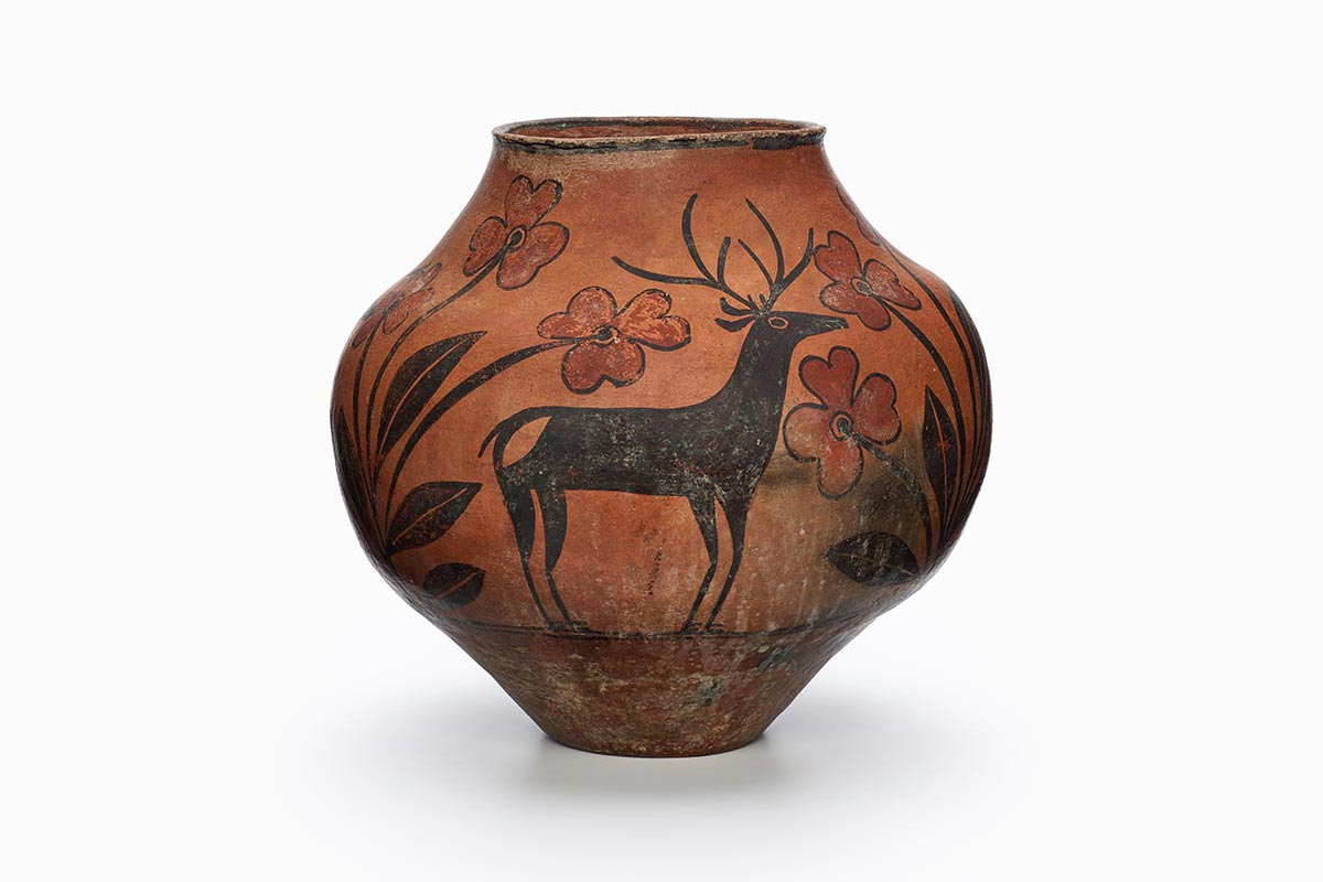 A Zia pot with a rarely-painted deer in the center surrounded by black and brown patterns.