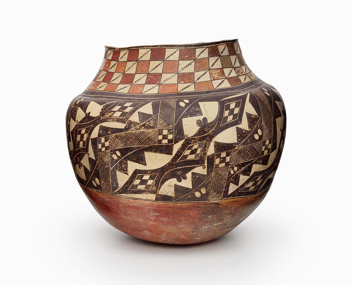 An Acoma olla with a brown and beige checkboard pattern atop a black and beige geometric design.