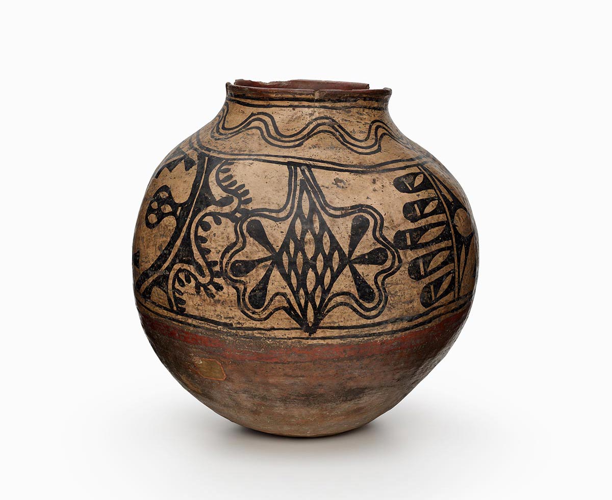 A storage jar with geometric triangles and a winding four-leaf motif.