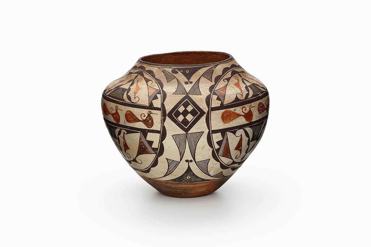 A four-color Acoma polychrome jar features white slip with black, red, and orange painted decoration.