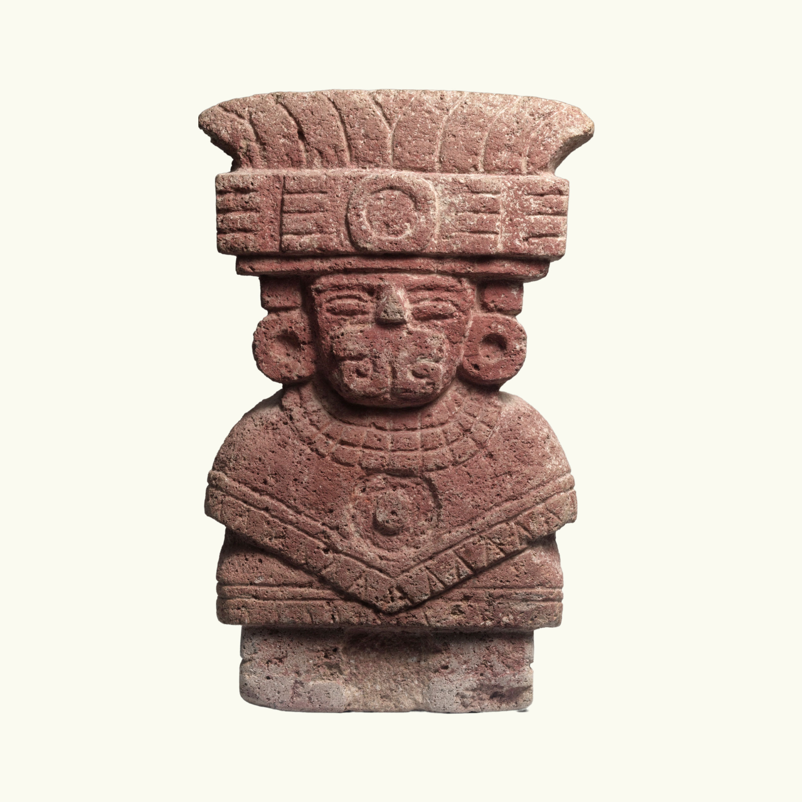 A seated goddess with a headdress made of volcanic stone and painted red.