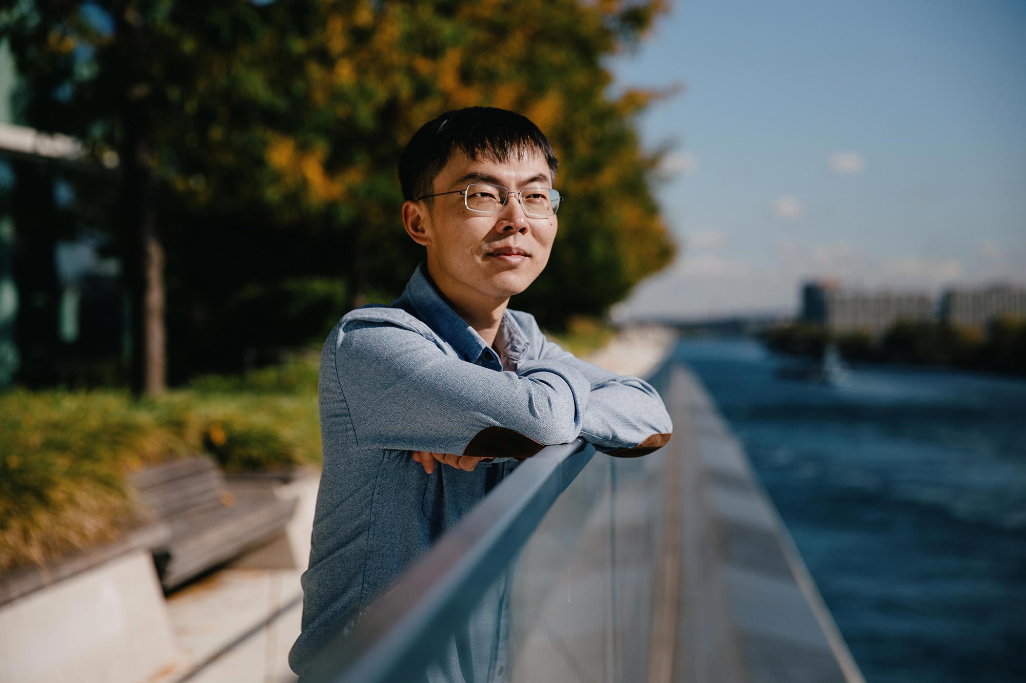 Shixin Liu leaning on a railing as he looks out at the water.